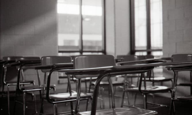 Picture of empty desks in an empty college classroom