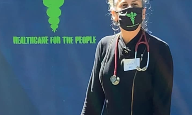 Picture of Dr. Widoff - a woman with gray hair pulled up, wearing a mask with a stethoscope around her neck