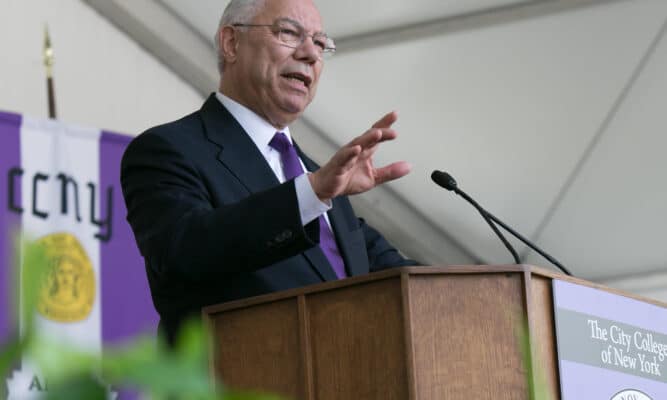 Powell speaking behind a podium.