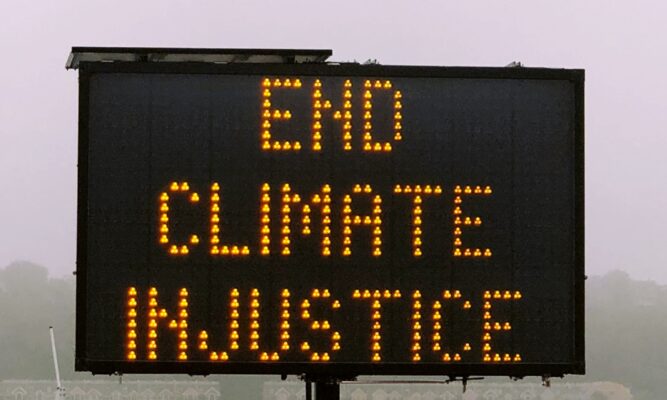 a sign that says End Climate Injustice