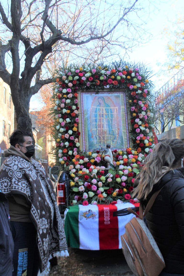 Van adorned with an arch of flowers, a Mexican flag and a portrait of the Virgin of Guadalupe.