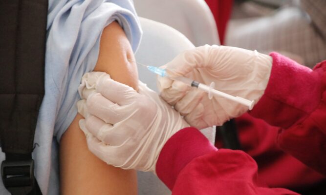 Photo of a student is being injected with a vaccine
