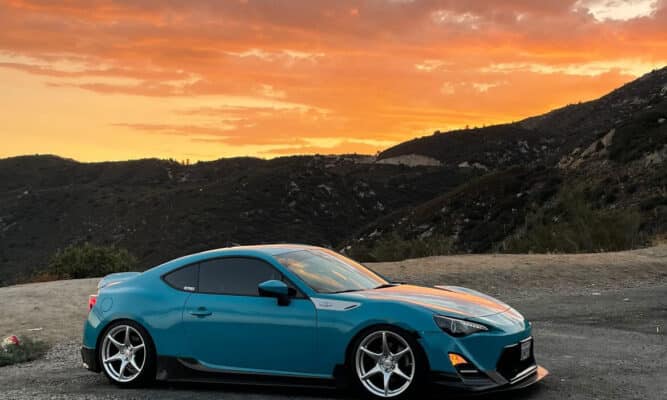 Image of a Scion FR-S with a sunset in the horizon.