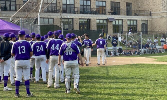 CCNY men's baseball team wearing purple and white run to celebrate a home run.