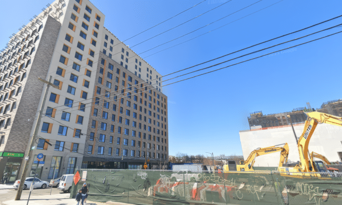 New building and vacant lot with construction in East New York