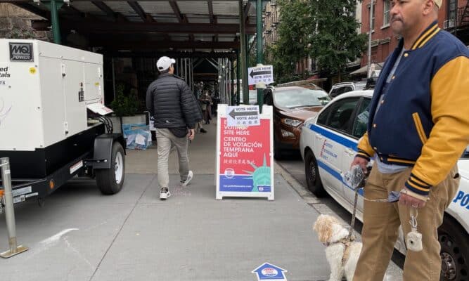 Vote Here sign man and dog