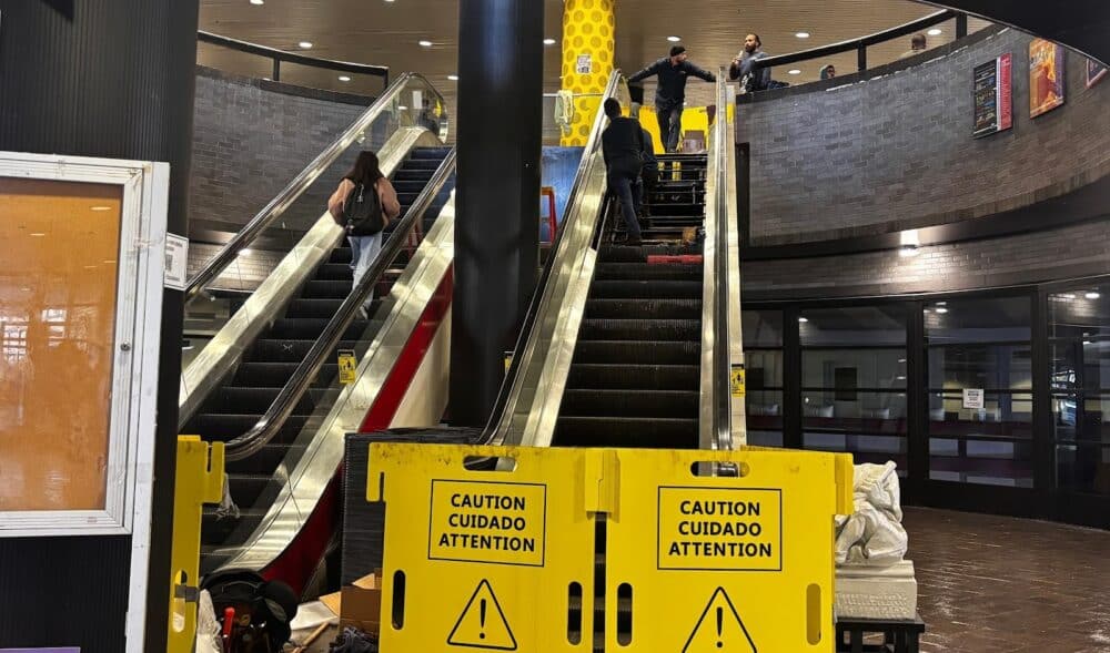 The two central escalators in NAC, the not on the right is out of service with a blockade while workers are on the top. Students are walking up the left escalators.