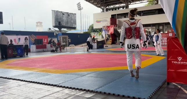 Jessica Gniedziejko walks on the taekwondo mat for one of her matches wearing her USA uniform.