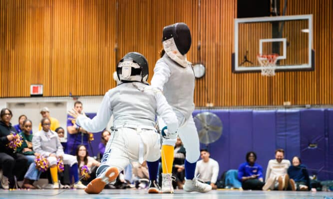 CCNY épée fencer Rabia Kashif lunges to attack her opponent from Hunter College.