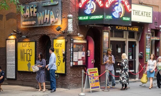 The corner of Cafe Wha? with customers surrounding the entrance.