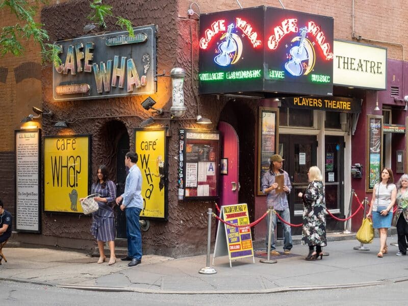 The corner of Cafe Wha? with customers surrounding the entrance.