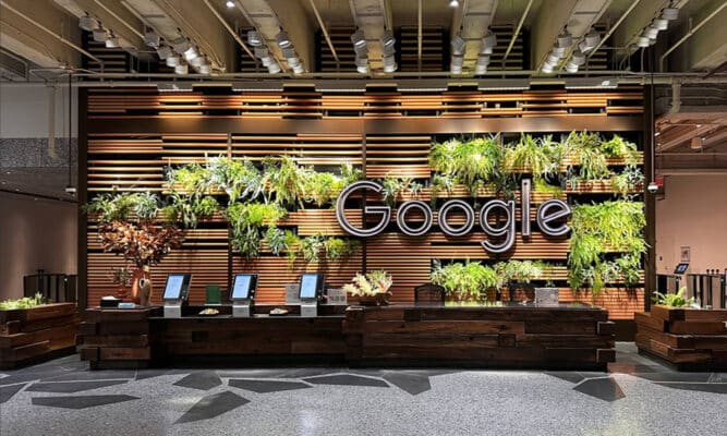 A photo of the Google’s newest headquarters with the use of bioliphic architecture, greenery integrated in the walls of the main wall of the main building entrance.