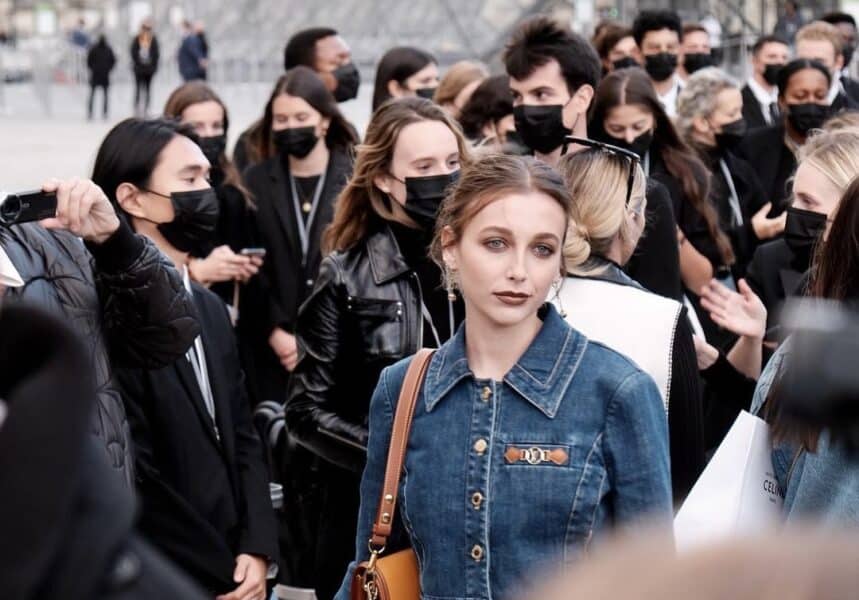 Emma Chamberlain stands in a crowd during Fashion Week