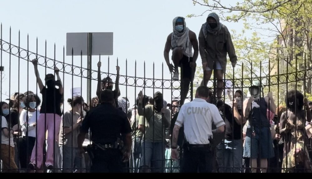 Pro-Palestinian Protestors trying to scale a fence at CCNY.