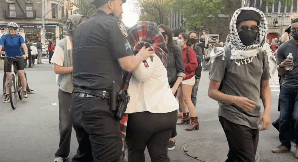 Screen shot of student protestors and a police officer
