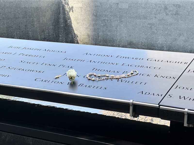 A flower and necklace on the 9/11 memorial pool 