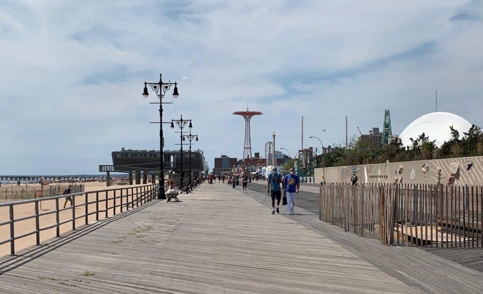The Coney Island boardwalk, men in distance.