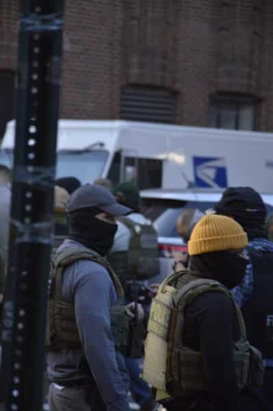 A group of masked federal agents with ICE agents on a Manhattan street.