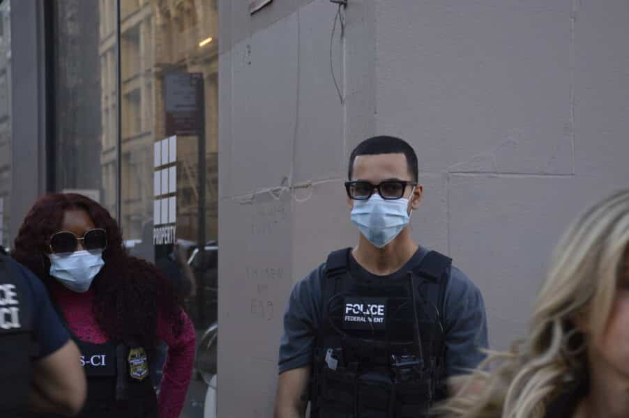 Two masked IRS-CI (Internal Revenue Service - Criminal Investigation) agents standing guard
