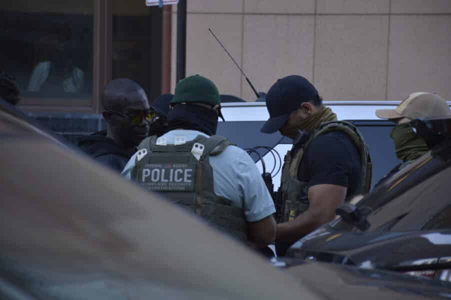 Homeland Security Investigations (HSI) federal agents in a huddle near Canal Street