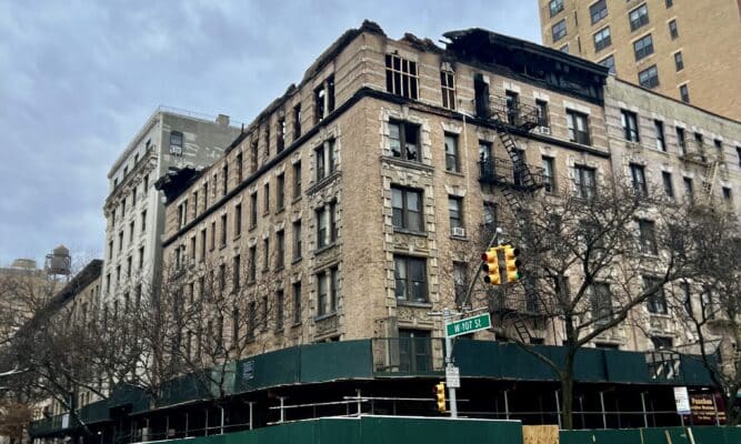 A burned apartment building with scaffolding surrounding it