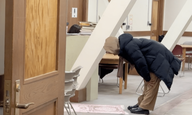 A Muslim student praying in Shepard Hall.