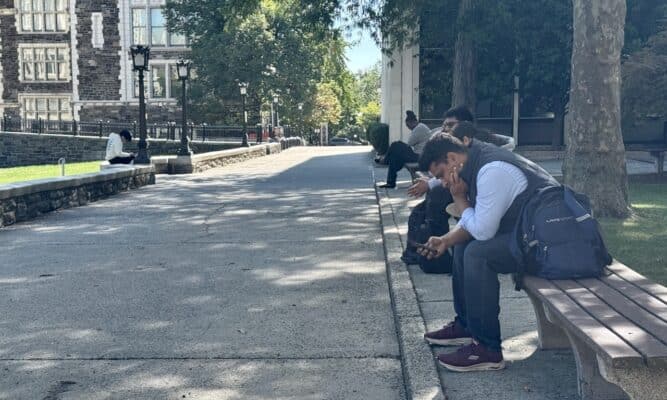 Students sitting alone on The City College of New York campus.