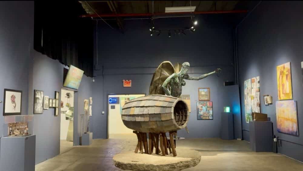 Gallery space with paintings and sculpture.