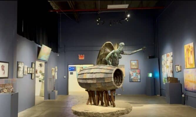 Gallery space with paintings and sculpture.