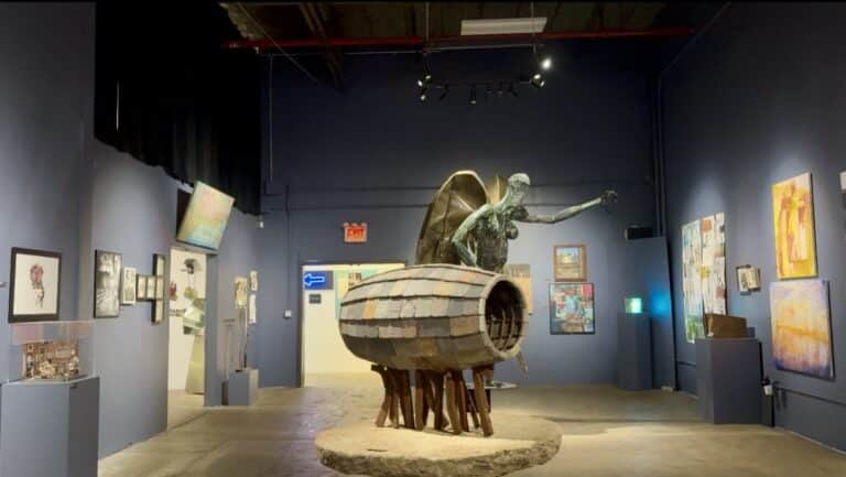 Gallery space with paintings and sculpture.