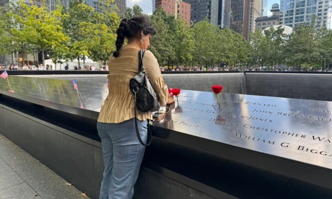 Iman Hussain putting red roses on the name Salman Hamdani at the World Trade Center Memorial.